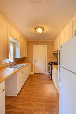 a large kitchen with a refrigerator a stove top oven a sink and dishwasher