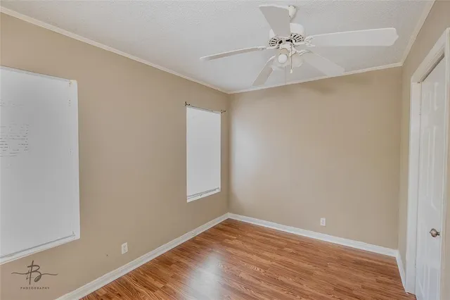 an empty room with a window and a ceiling fan