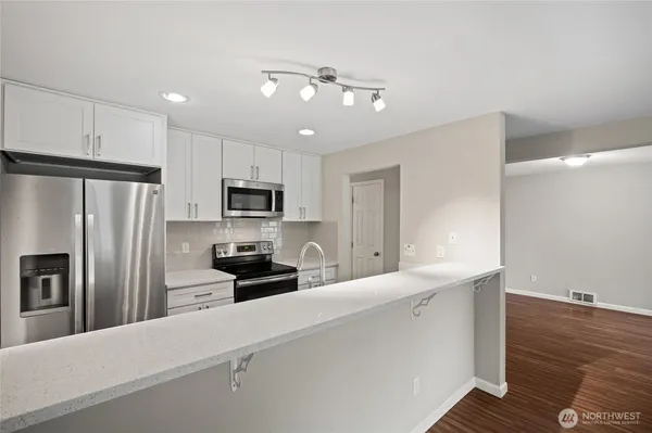 a kitchen with stainless steel appliances a refrigerator sink and stove