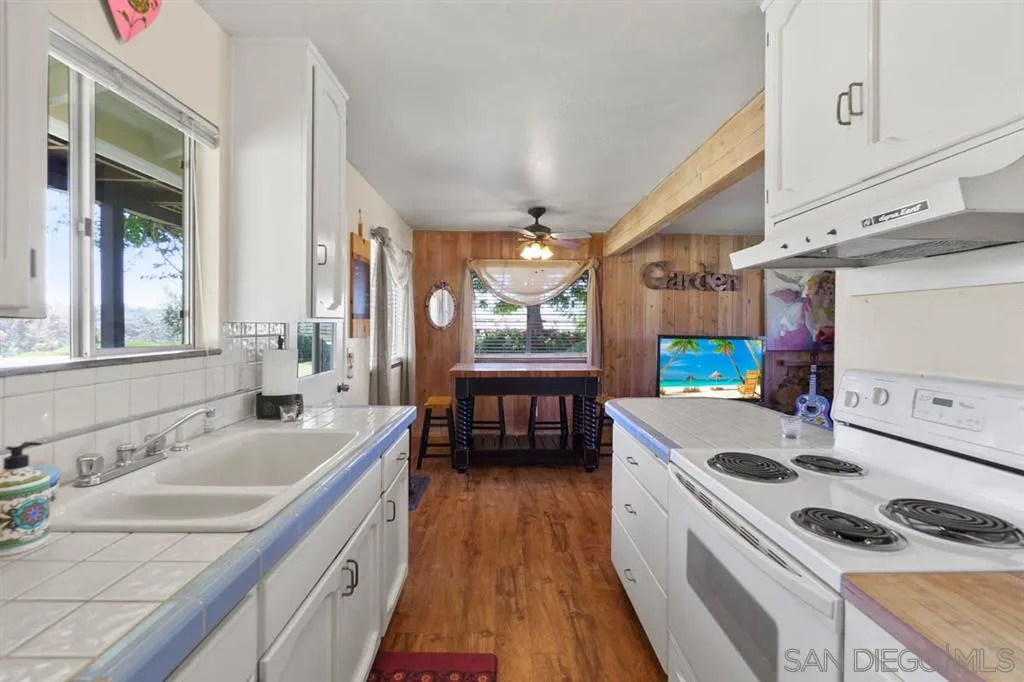 Encinitas, CA 92024 - Photo 10 of 12 a kitchen that has a sink a stove and a wooden floor