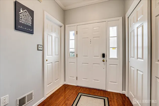 a kitchen with stainless steel appliances a stove a sink a microwave a dining table and chairs