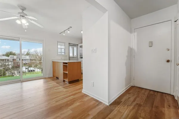 a view of a kitchen with wooden floor and a window