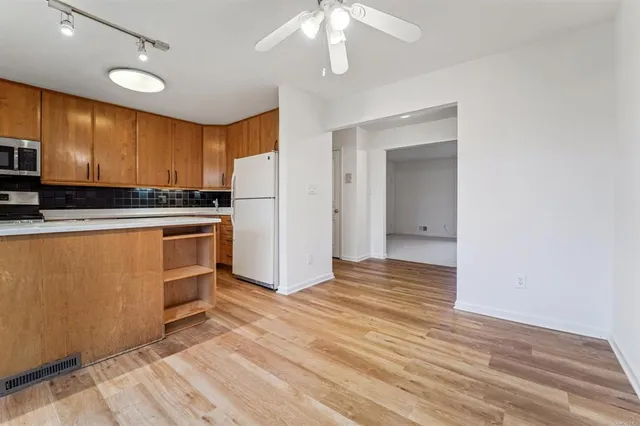 a kitchen with granite countertop a stove a sink and a refrigerator