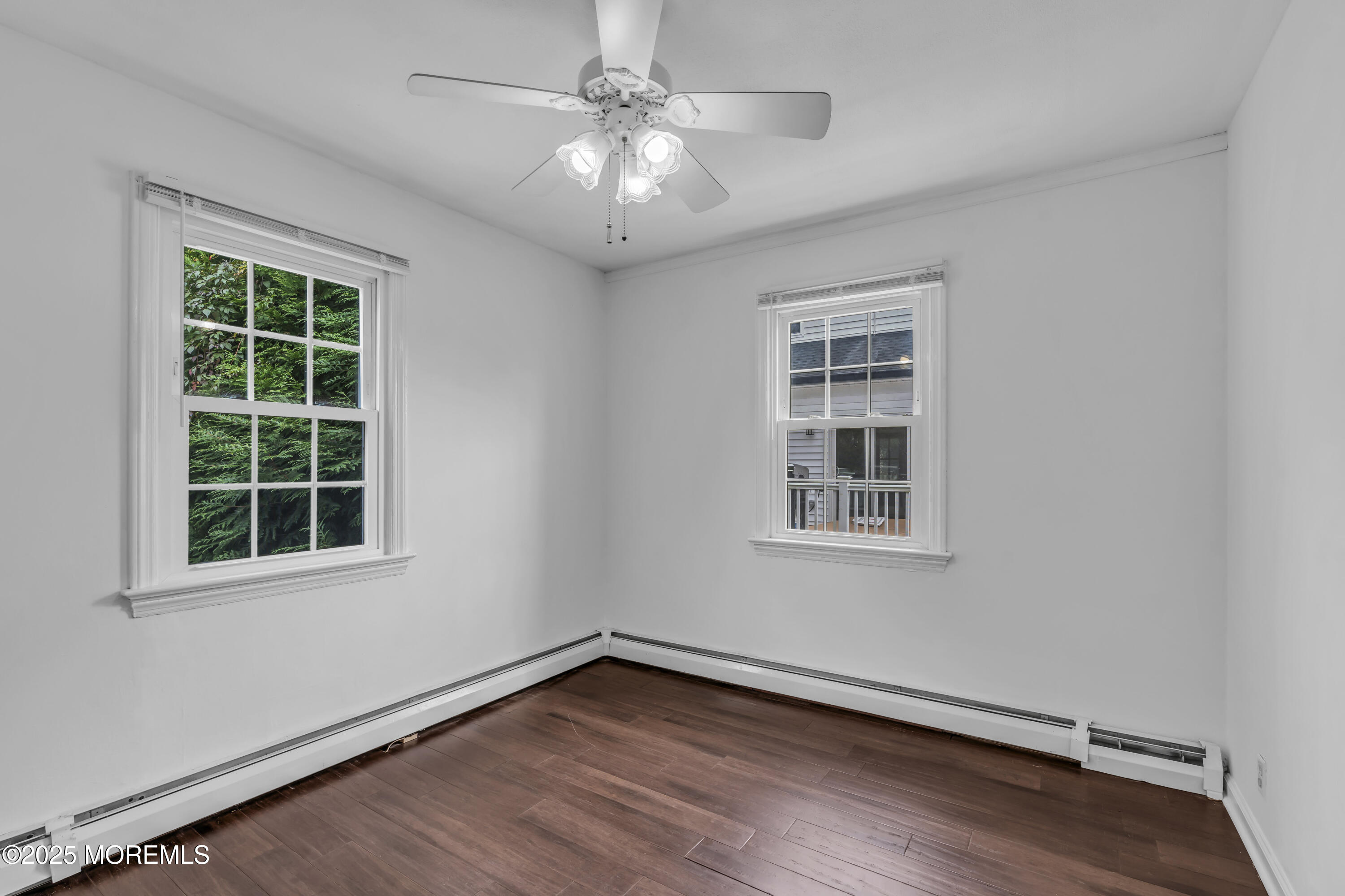 2 Schiverea Avenue Freehold, NJ 07728 - Photo 15 of 36 an empty room with wooden floor chandelier fan and windows