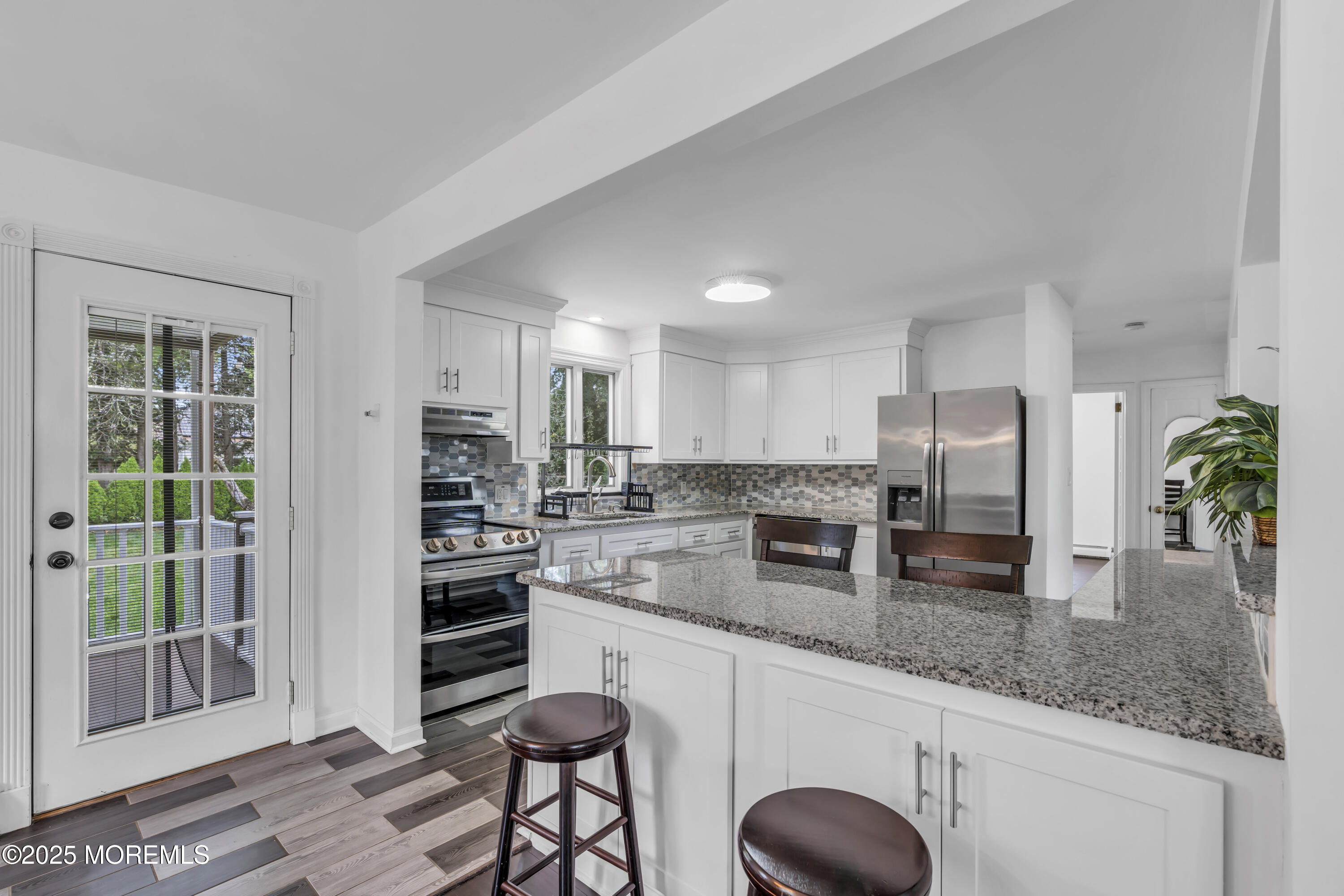 2 Schiverea Avenue Freehold, NJ 07728 - Photo 10 of 36 a kitchen with stainless steel appliances granite countertop a stove a sink a refrigerator and white cabinets with wooden floor