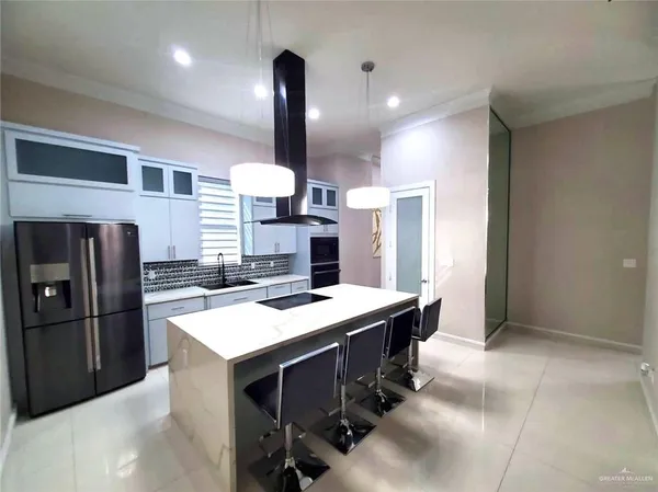 a kitchen with stainless steel appliances kitchen island granite countertop a refrigerator and a stove top oven