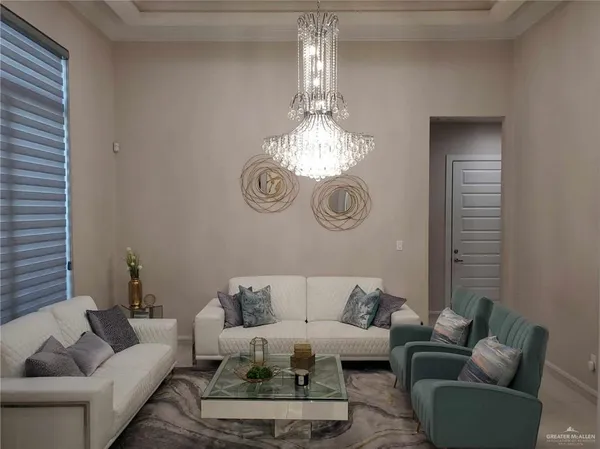 a living room with furniture a chandelier and a window