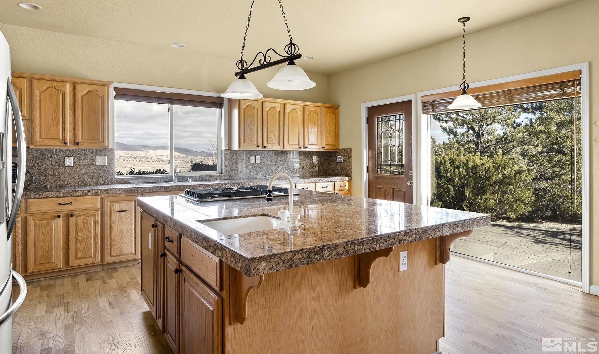 3420 Cheechako Drive Reno, NV 89519 - Photo 4 of 30 a kitchen with stainless steel appliances granite countertop a sink a stove a refrigerator a counter top space and living room view