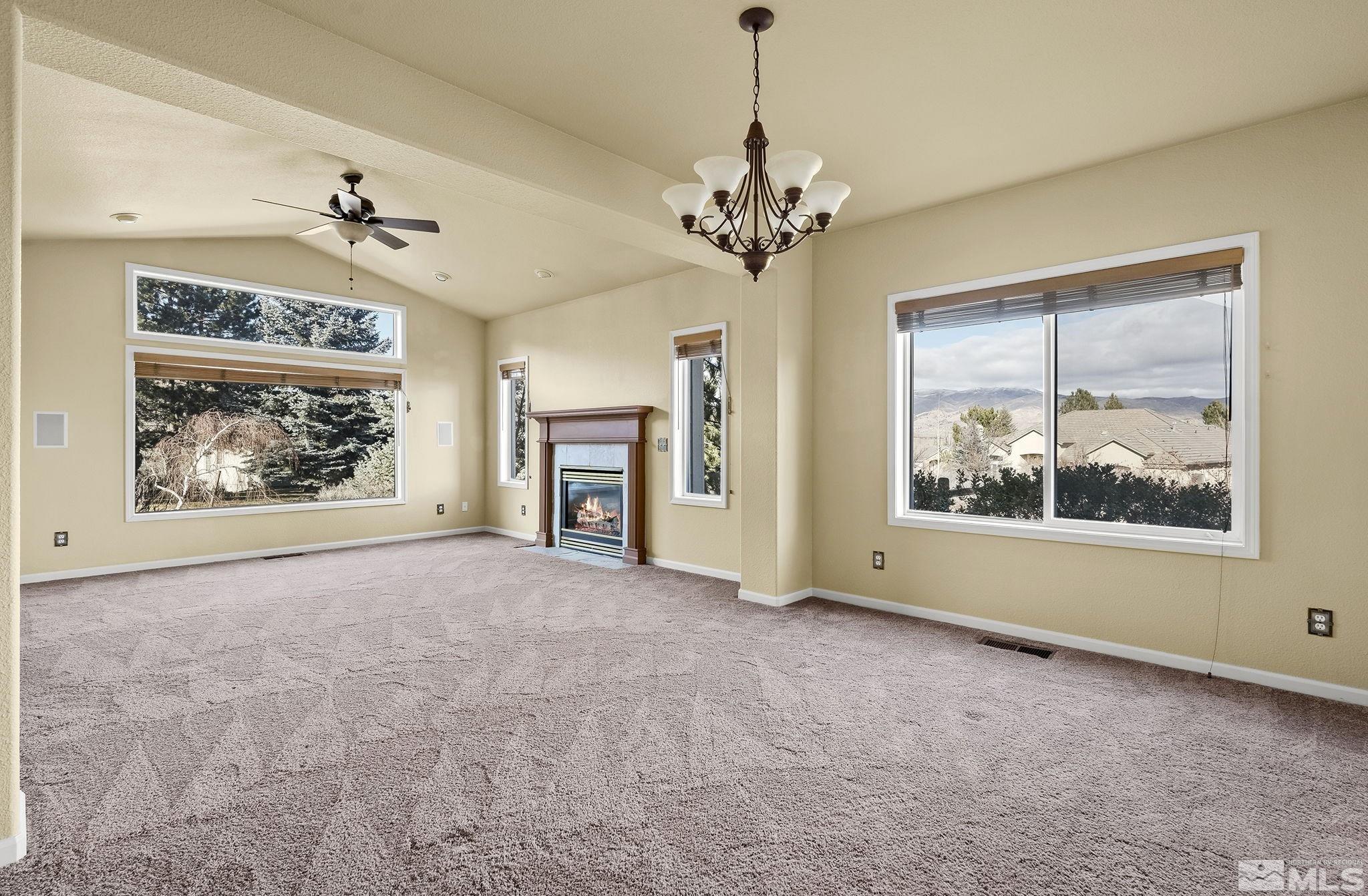 3420 Cheechako Drive Reno, NV 89519 - Photo 10 of 30 an empty room with windows fireplace and fans