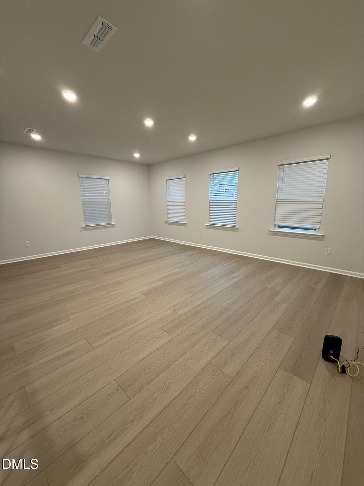 7224 Morris Acres Road Apex, NC 27523 - Photo 11 of 23 an empty room with wooden floor and windows