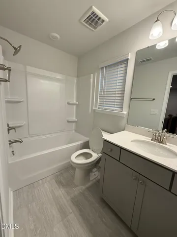 a bathroom with a toilet a sink a large mirror and bathtub