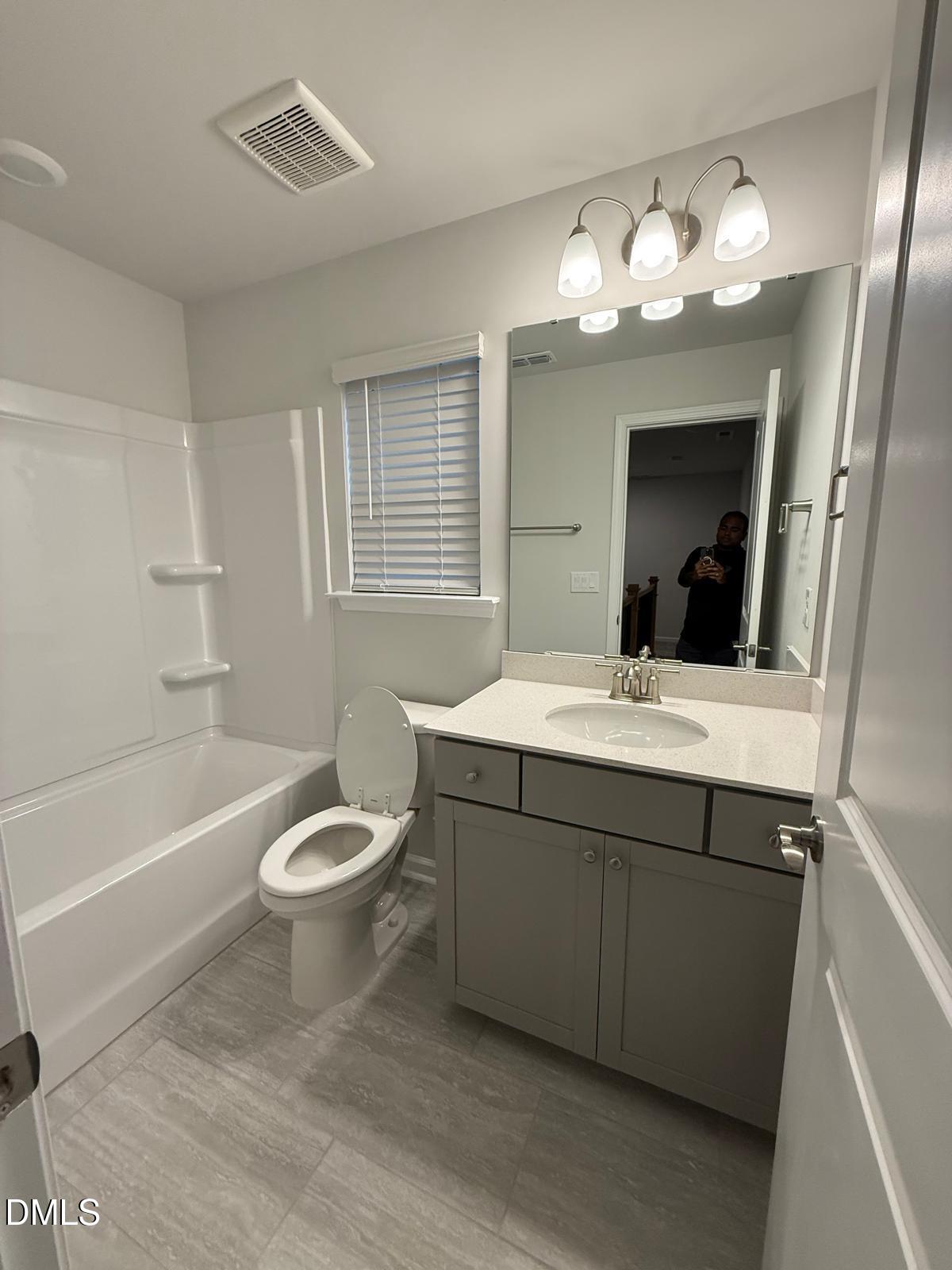 7224 Morris Acres Road Apex, NC 27523 - Photo 18 of 23 a bathroom with a toilet a sink a large mirror and bathtub