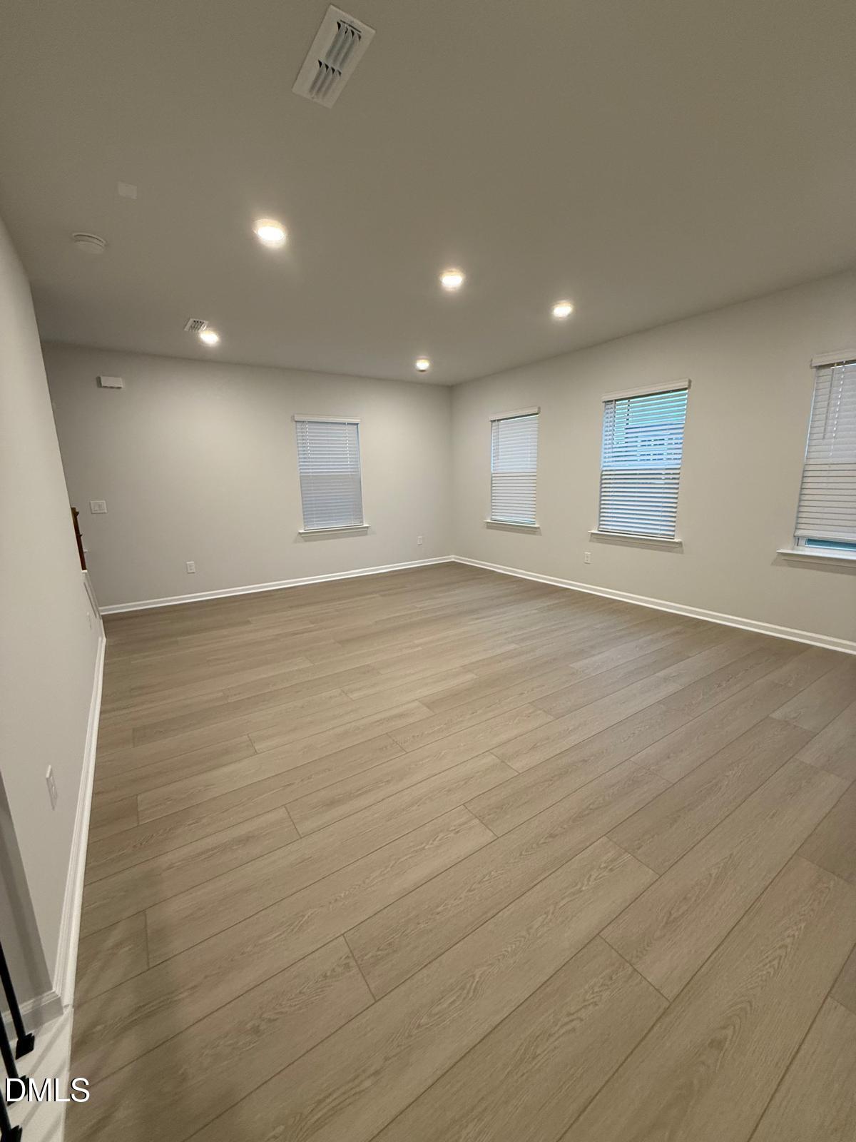 7224 Morris Acres Road Apex, NC 27523 - Photo 10 of 23 an empty room with wooden floor and windows