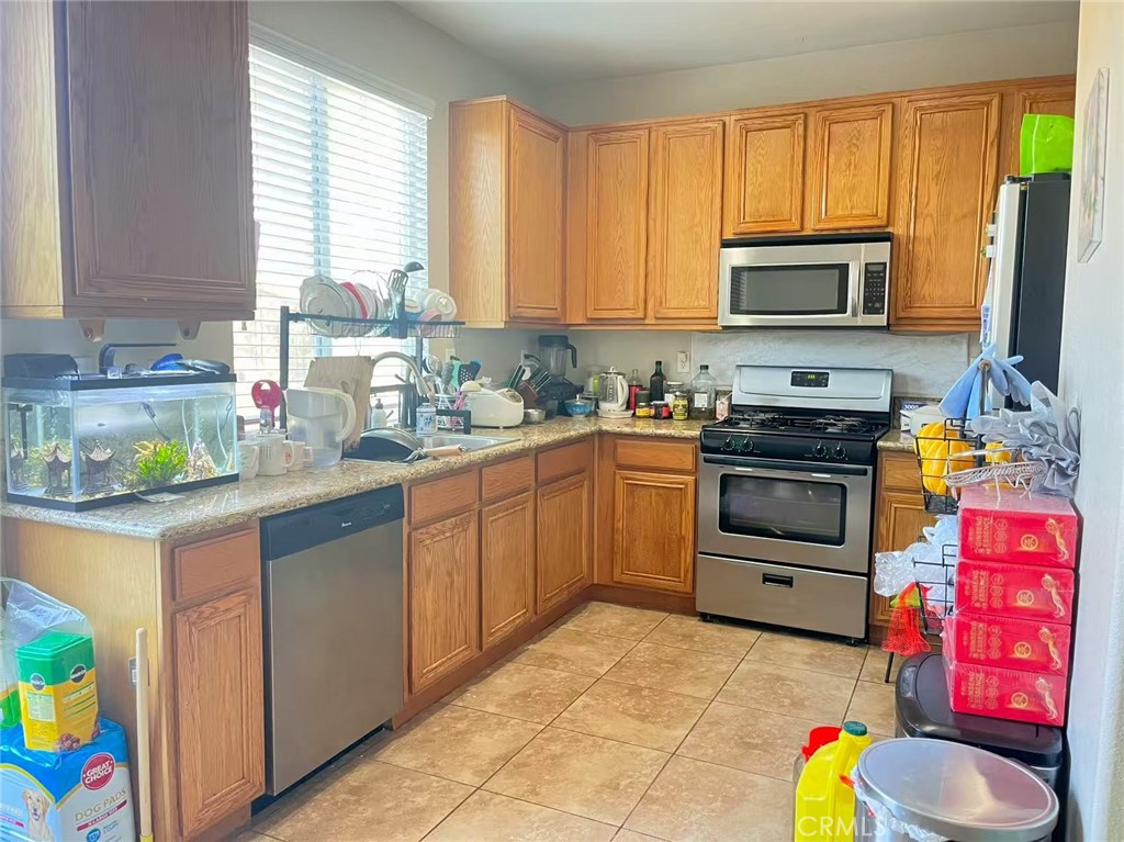 1662 Palermo Drive Riverside, CA 92507 - Photo 5 of 30 a kitchen with stainless steel appliances a stove sink microwave and cabinets