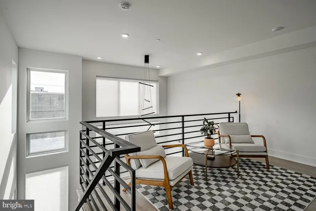 a living room with furniture a rug and white walls