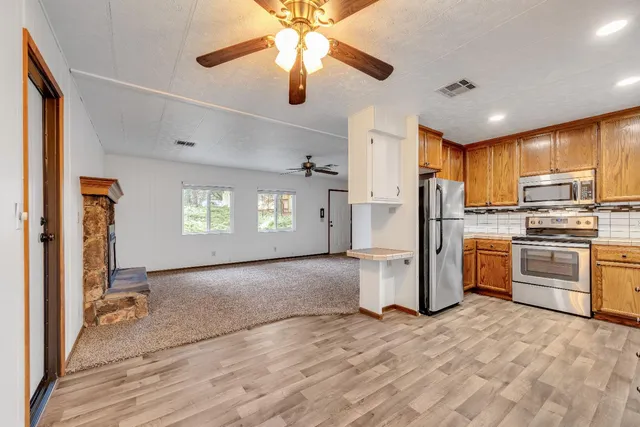 a view of a kitchen with a stove cabinets and a ceiling fan