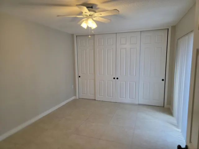 an empty room with chandelier fan