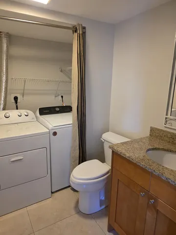 a bathroom with a granite countertop toilet sink and mirror