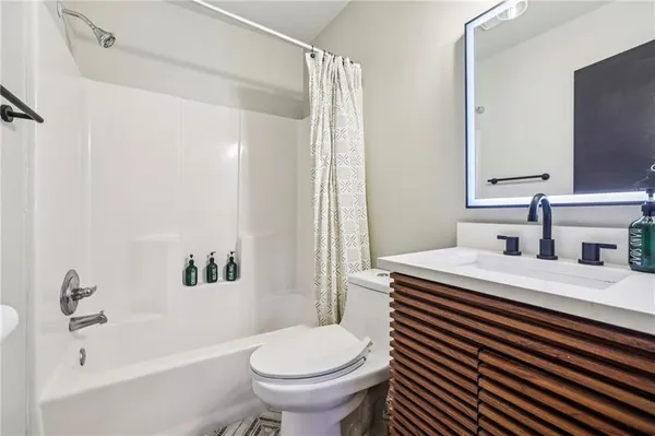 a bathroom with a sink toilet vanity and tub