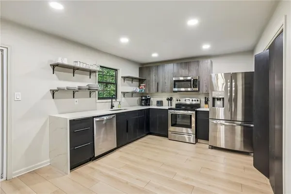 a kitchen with granite countertop a refrigerator and a stove top oven