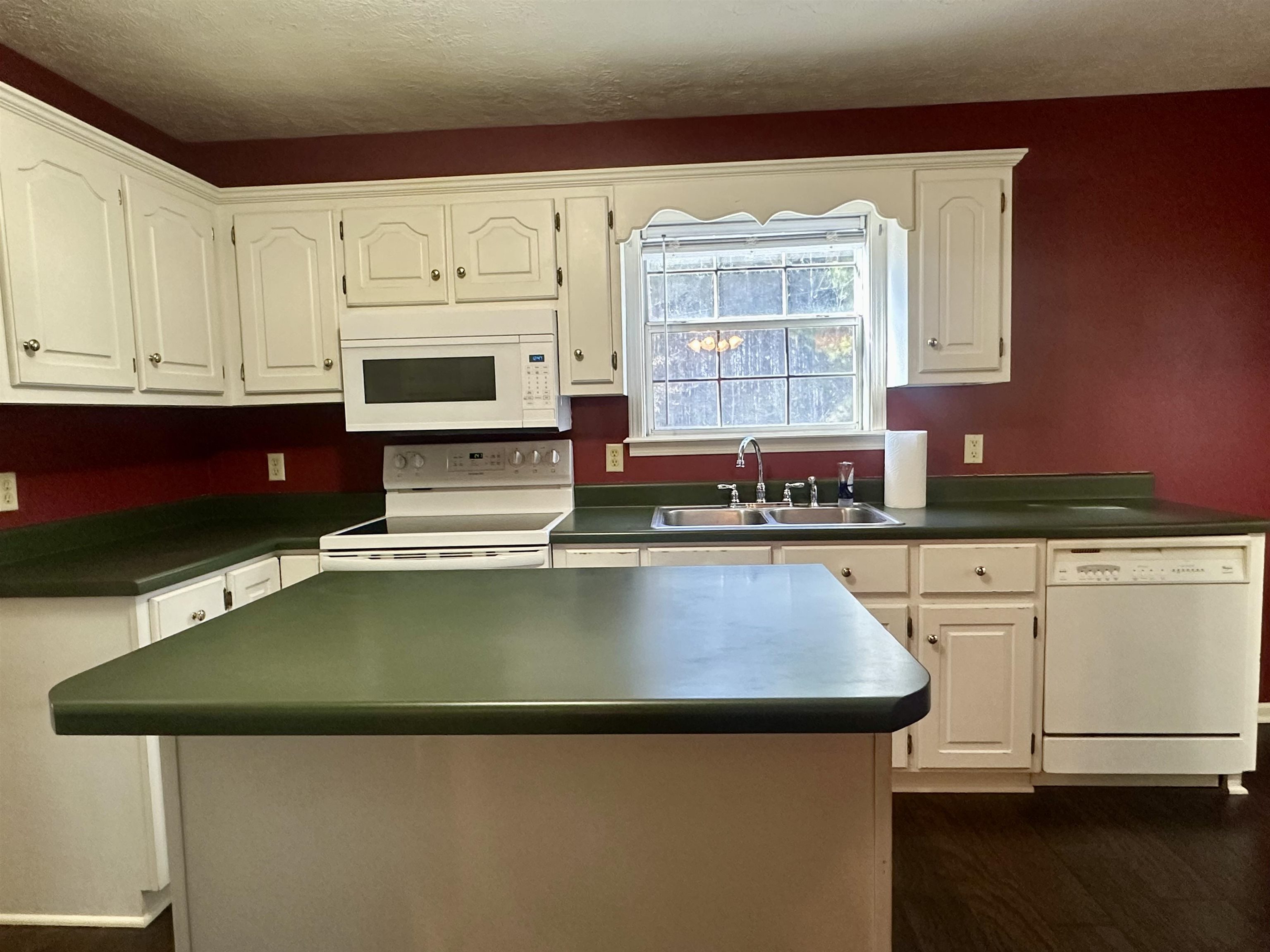 3566 Highway 142 Selmer, TN 38375 - Photo 17 of 20 Kitchen with white appliances, a kitchen island, dark wood-type flooring, and white cabinetry