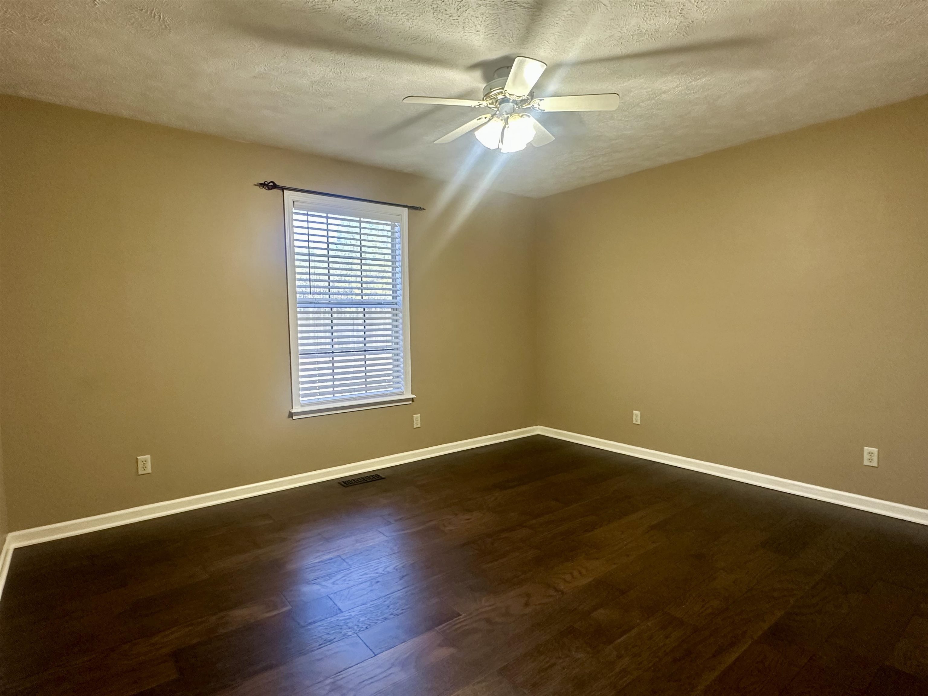 3566 Highway 142 Selmer, TN 38375 - Photo 20 of 20 Spare room with dark wood finished floors, a textured ceiling, and ceiling fan