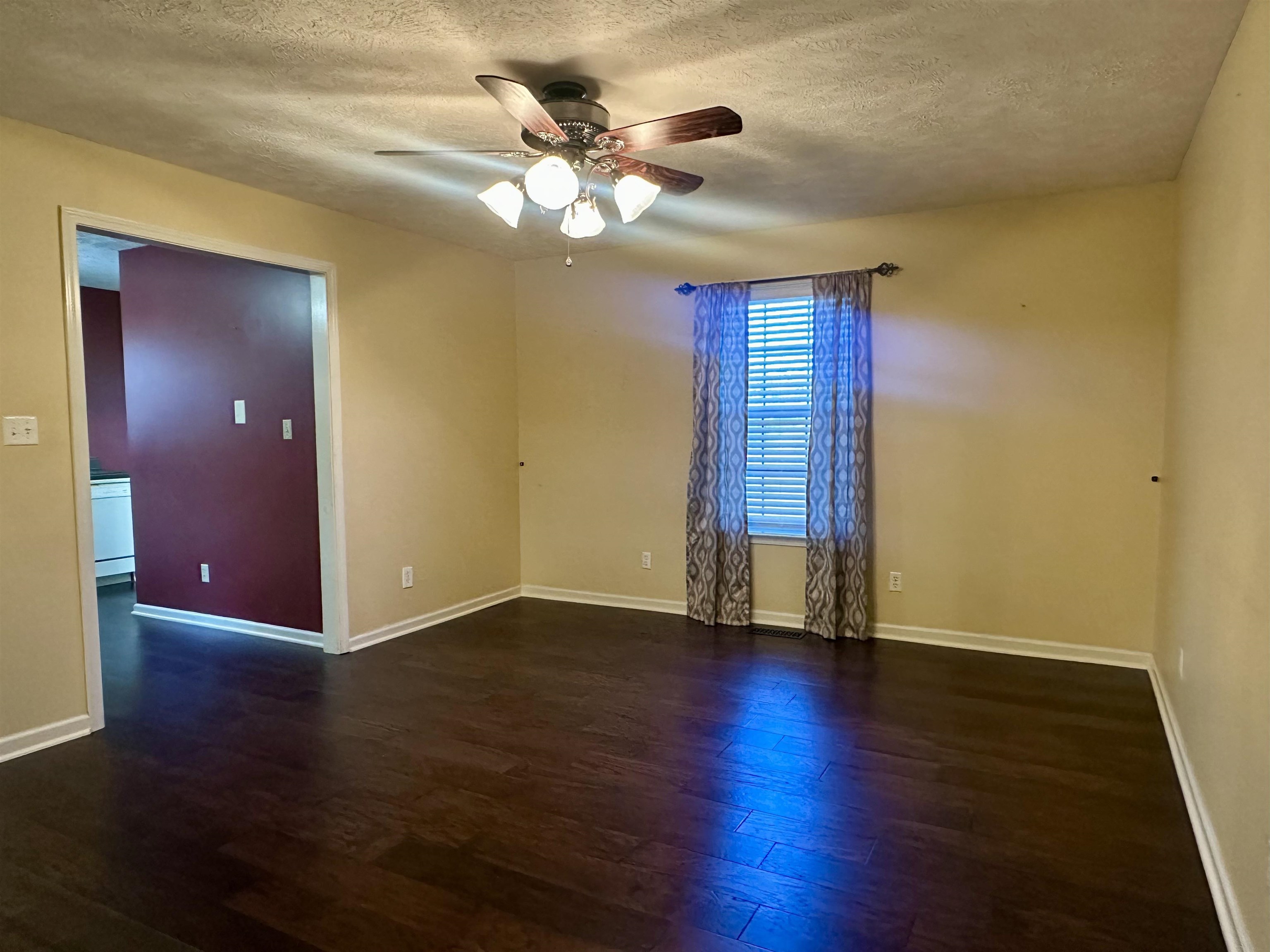 3566 Highway 142 Selmer, TN 38375 - Photo 3 of 20 Spare room featuring a ceiling fan, a textured ceiling, and dark wood finished floors