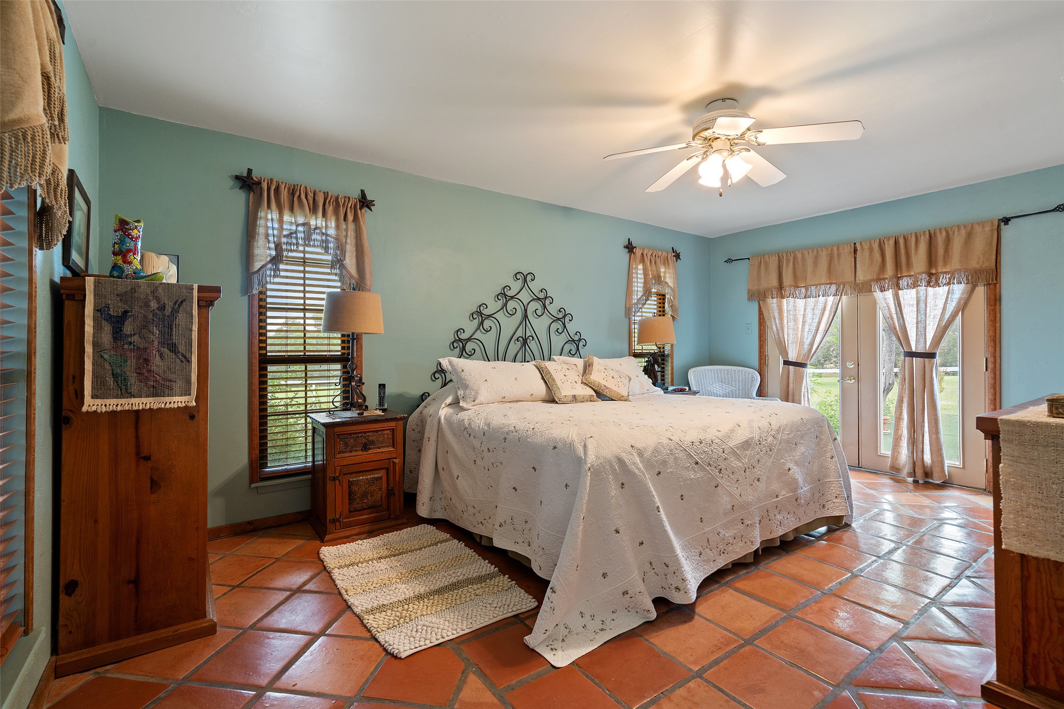 23200 Fulkes Road Leander, TX 78641 - Photo 9 of 15 Terracotta tile floors and a ceiling fan create a comfortable atmosphere in this inviting bedroom.