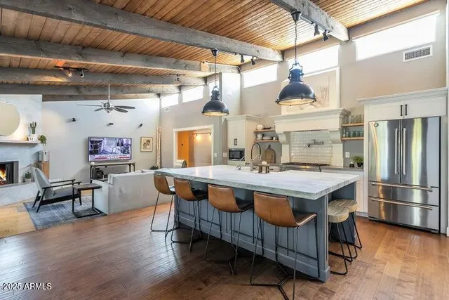 a kitchen with stainless steel appliances granite countertop a table chairs and wooden floors