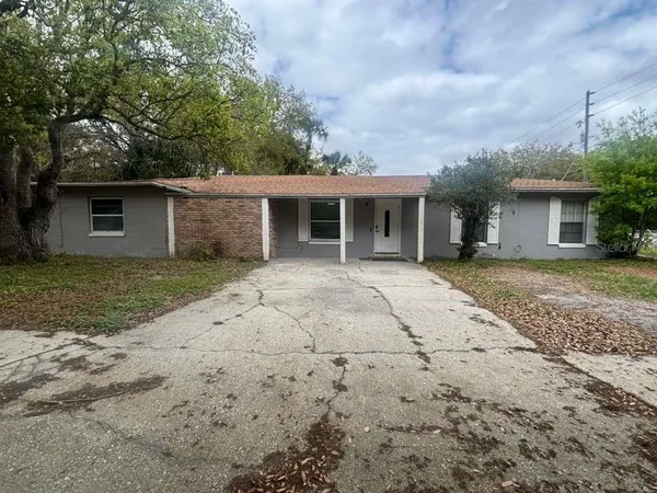 a front view of house with yard and trees around