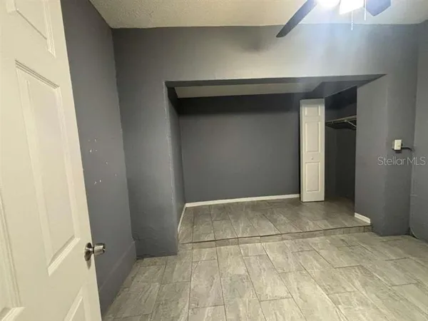 an empty room with a chandelier fan