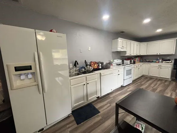 a kitchen with white cabinets and white appliances