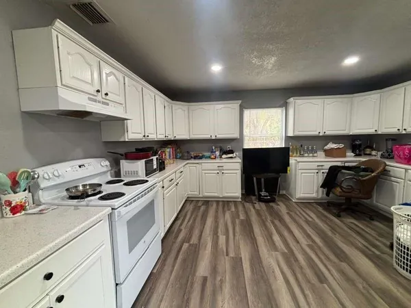 a kitchen with granite countertop a stove sink and cabinets