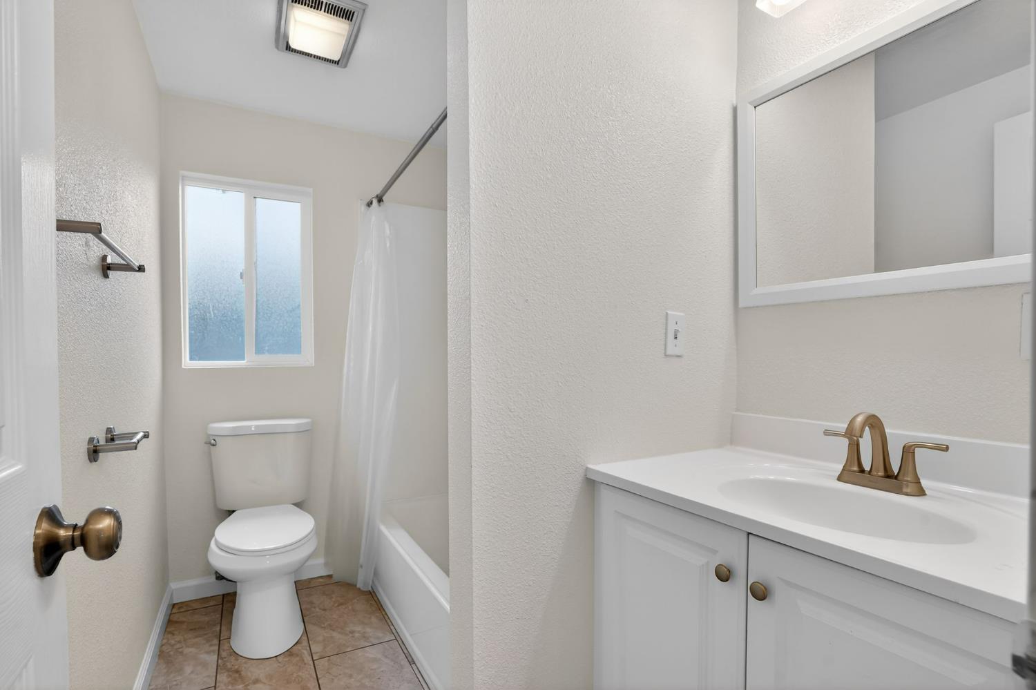 418 East Granger Avenue Modesto, CA 95350 - Photo 13 of 23 a bathroom with a toilet a sink and mirror