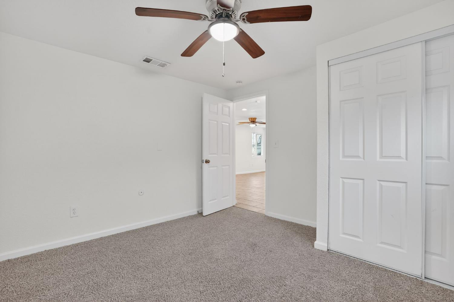 418 East Granger Avenue Modesto, CA 95350 - Photo 15 of 23 an empty room with closet and a chandelier fan