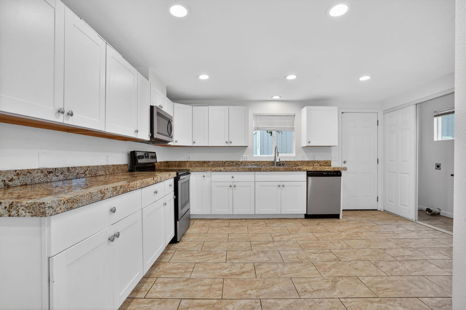 418 East Granger Avenue Modesto, CA 95350 - Photo 4 of 23 a large kitchen with stainless steel appliances granite countertop a stove a sink dishwasher and a refrigerator