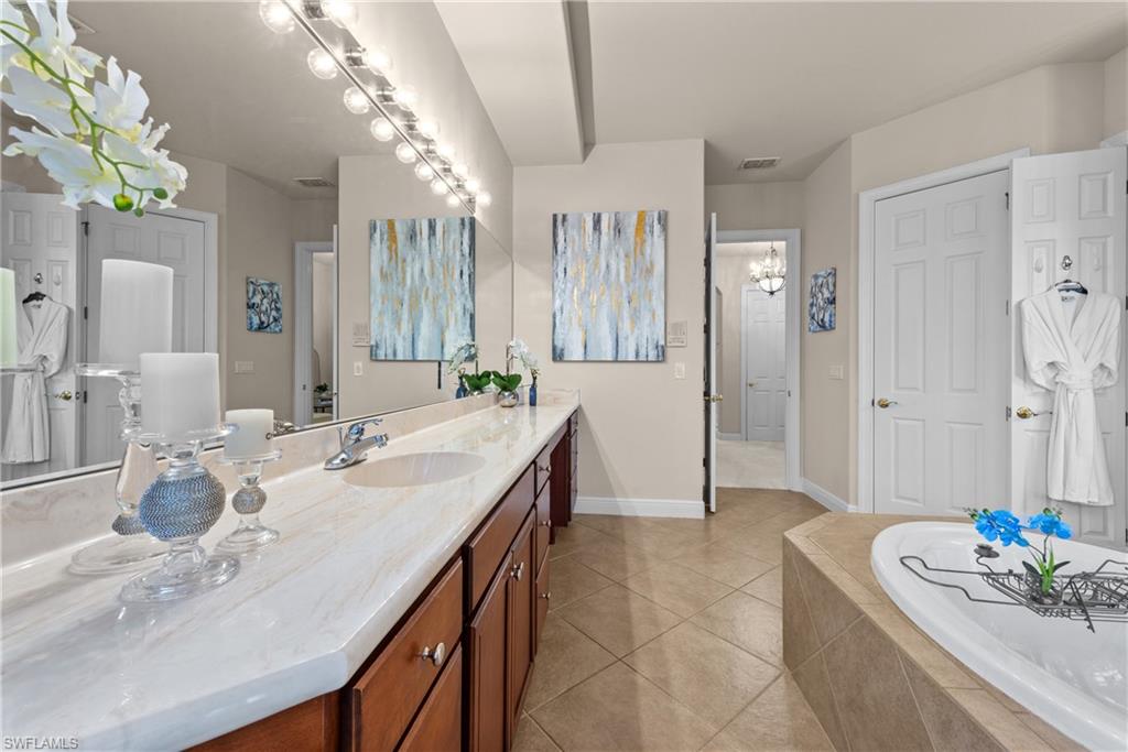 19261 La Serena Drive Estero, FL 33967 - Photo 18 of 48 a spacious bathroom with a granite countertop sink a toilet a mirror and shower