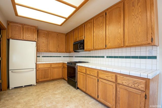 a kitchen with stainless steel appliances granite countertop a refrigerator sink and cabinets