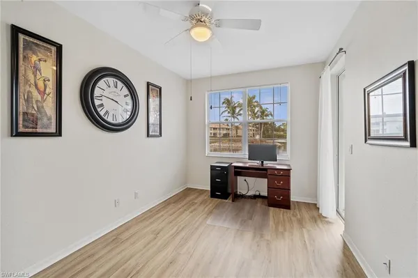 a view of a workspace with furniture and a window