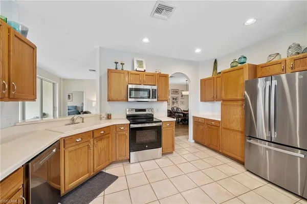 a kitchen with stainless steel appliances a refrigerator sink and microwave