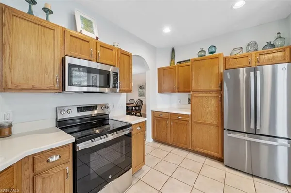a kitchen with a refrigerator a stove top oven a sink and cabinets