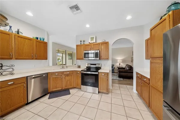 a kitchen with stainless steel appliances granite countertop a sink and a refrigerator