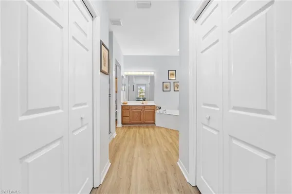 a view of a hallway with wooden floor and furniture