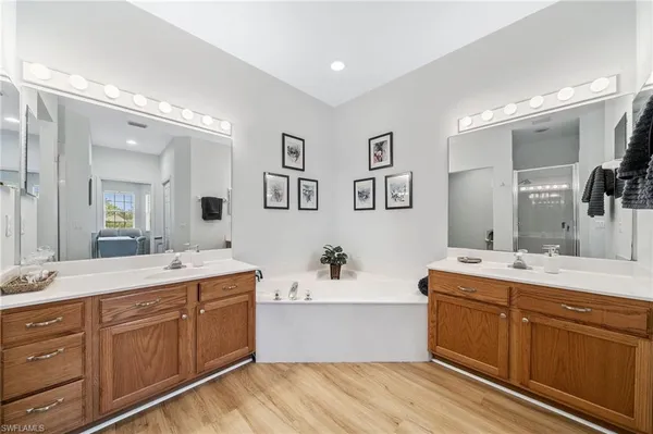a bathroom with a double vanity sink mirror and bathtub
