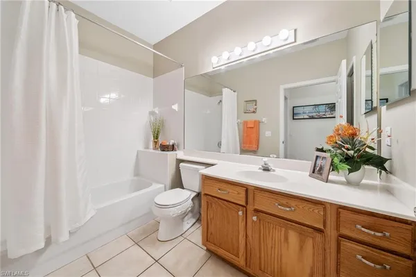 a spacious bathroom with a granite countertop sink a toilet a mirror and shower