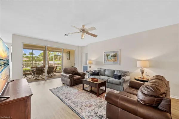 a living room with furniture ceiling fan and a window