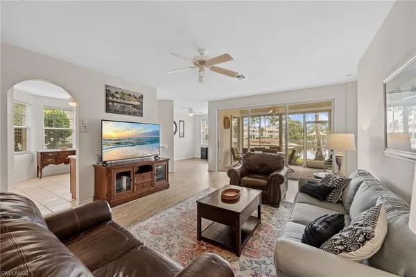 a living room with furniture flat screen tv and a large window