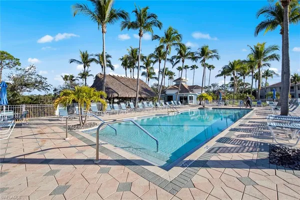 a view of a swimming pool with a patio and palm trees