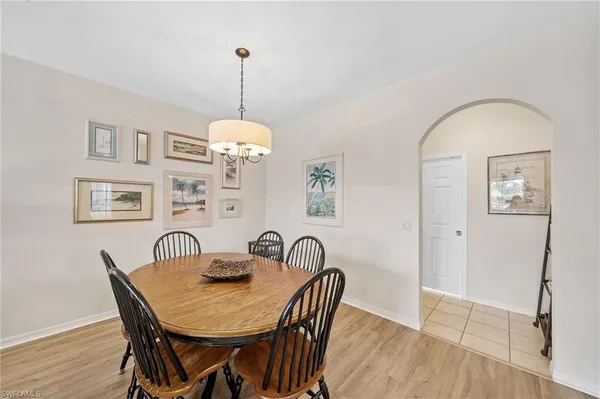 a dining room with furniture a chandelier and wooden floor
