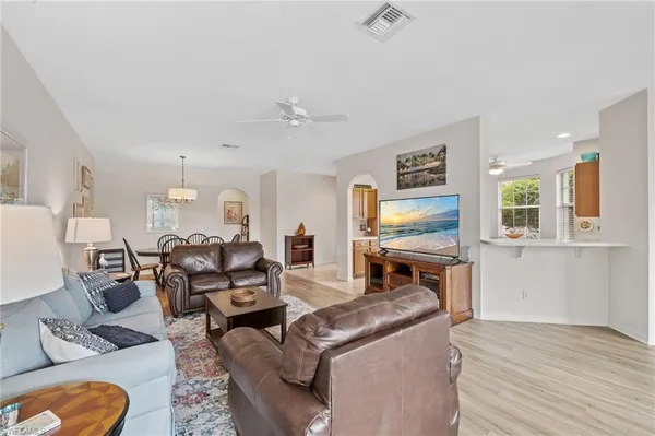 a living room with furniture flat screen tv and window